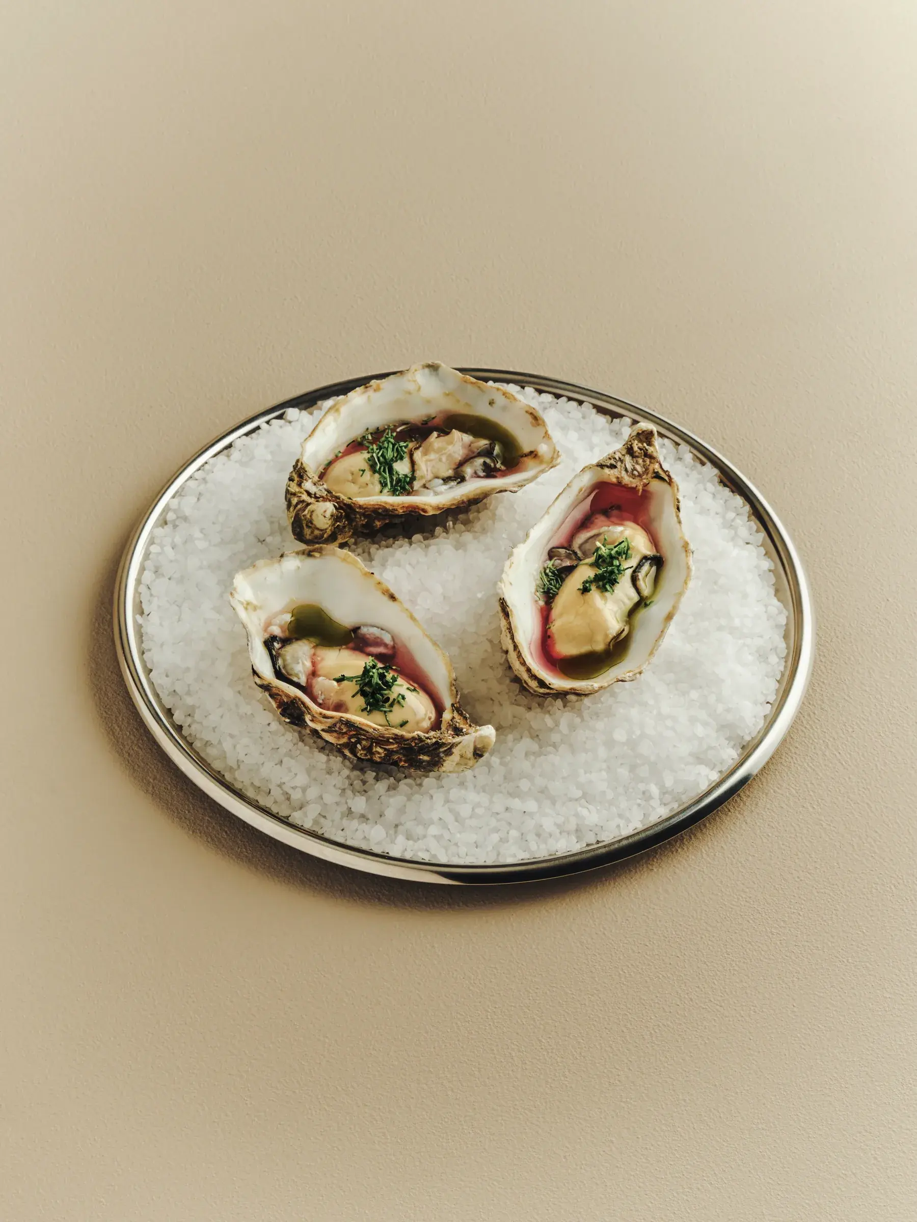 Three oysters served on salt