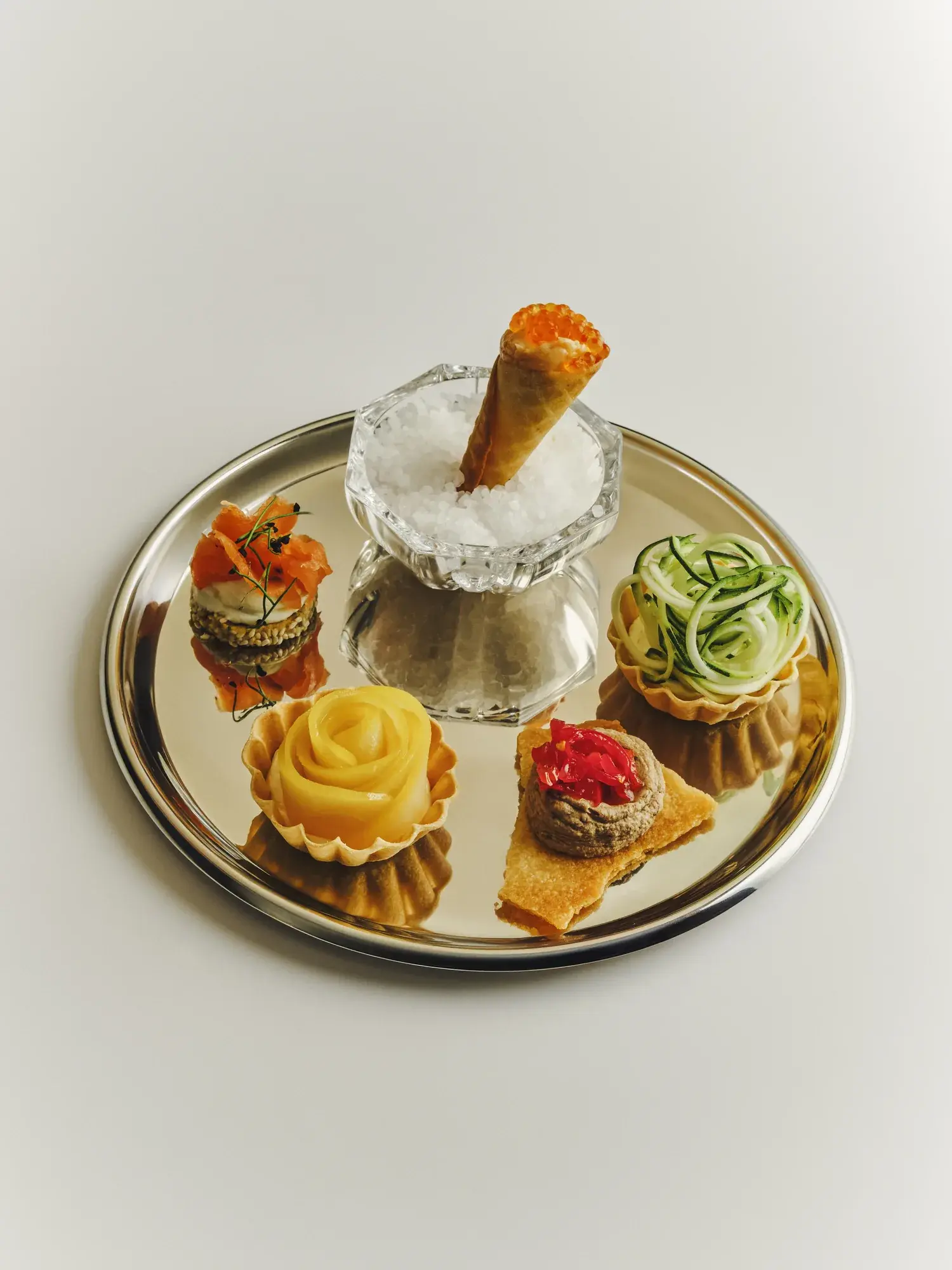 Canapés on a silver tray with a salmon roe cone