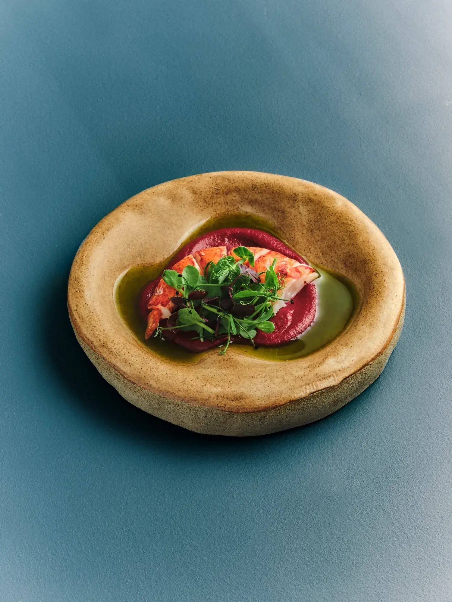 A lobster dish against a blue surface