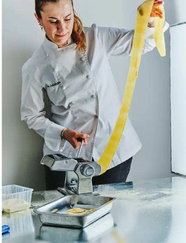 Pınar İshakoğlu rolling pasta dough through the machine