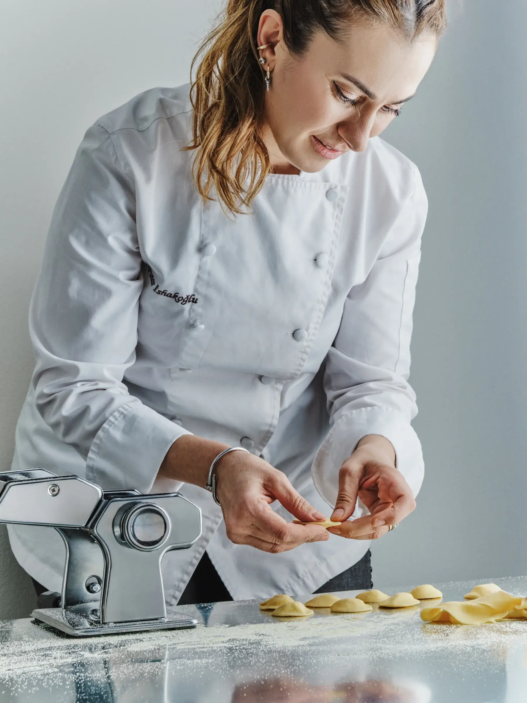 Pınar İshakoğlu folding tortellini beside the pasta machine