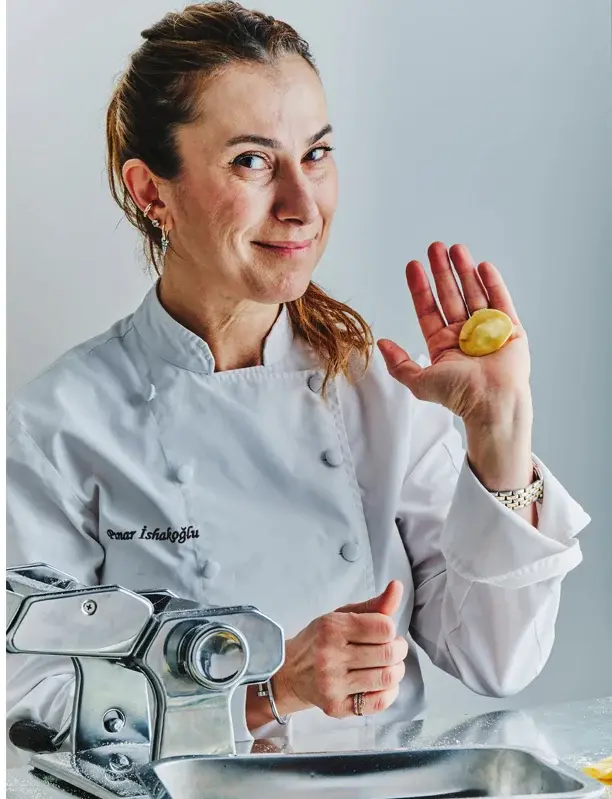 Pınar İshakoğlu smiling with a tortellino in her hand